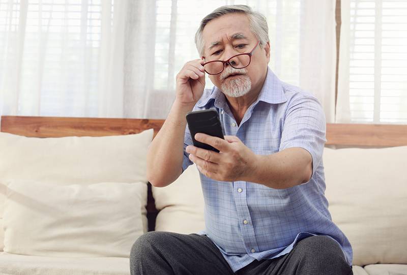 Older man having trouble using a smartphone