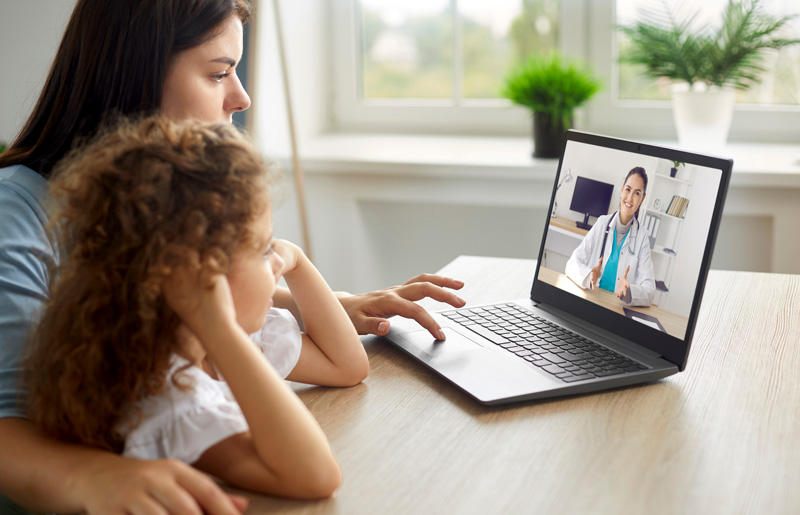 A mother and her daughter having a telehealth consultation with a doctor