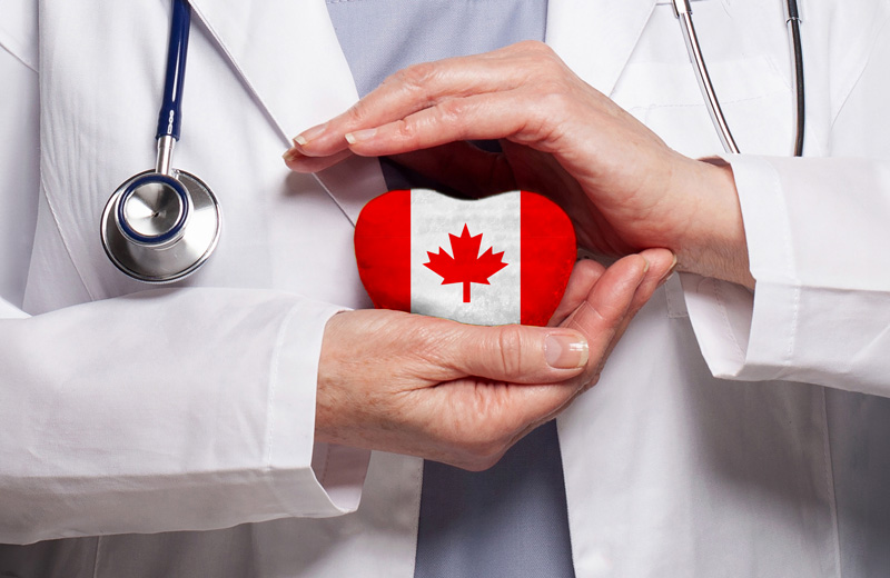 Canadian flag on a heart in between healthcare provider's hands