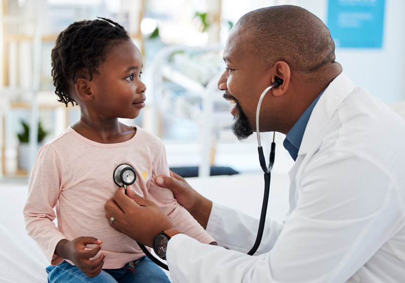 Healthcare provider listening to little girl's heart
