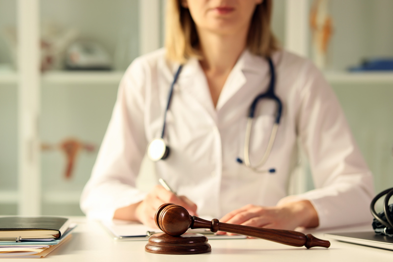 Healthcare provider in front of a judge's gavel for medical decision-making