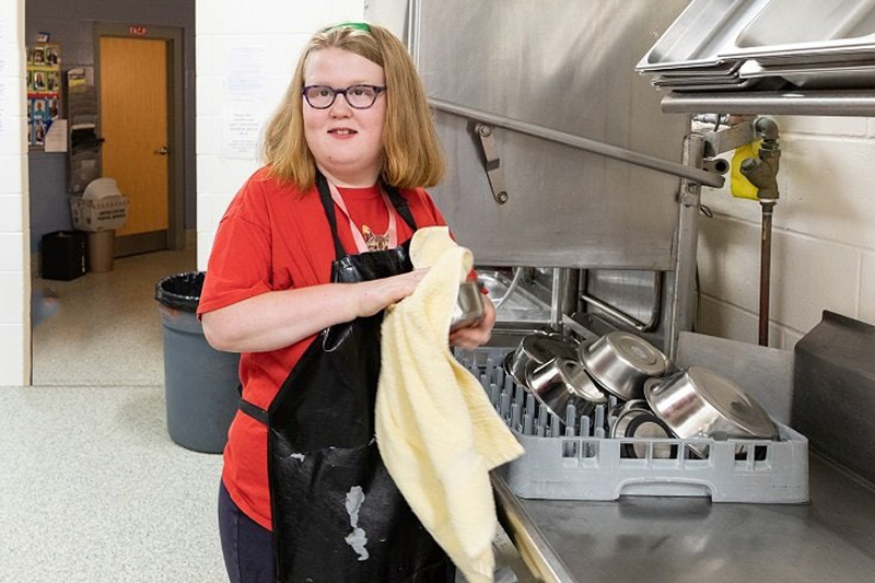 A student explores a new job opportunity washing dishes in an industrial kitchen.