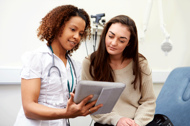 Nurse Showing Patient Test Results On Digital Tablet