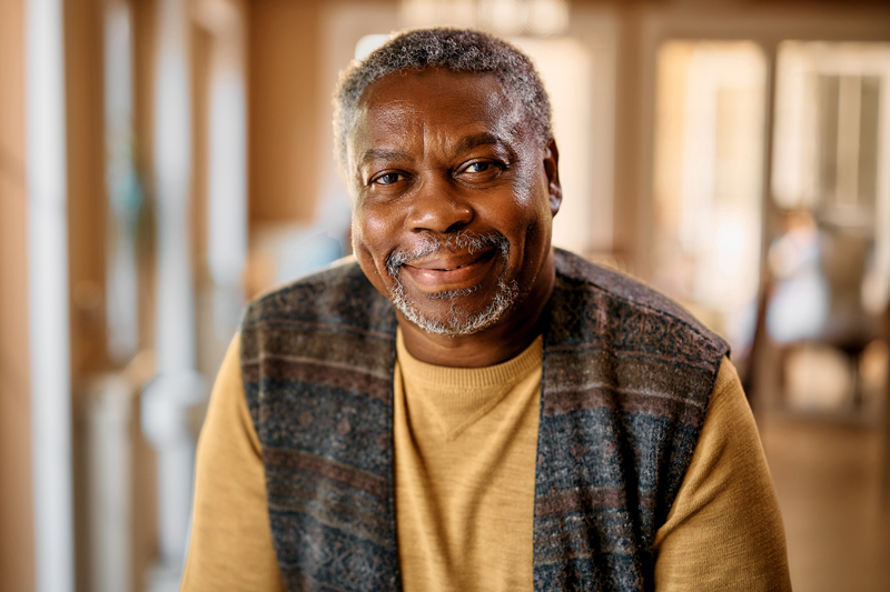 Happy African American senior at nursing home looking at camera.