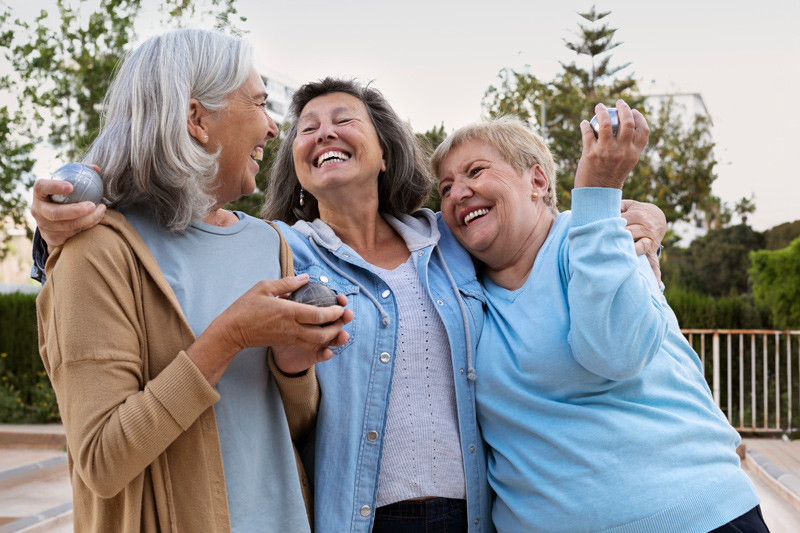 Three older women laughing together