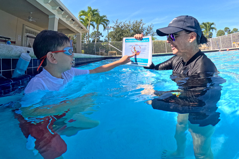 Autism‑informed swim instruction in progress: Instructor uses visual supports and graduated prompting in 1:1 lesson