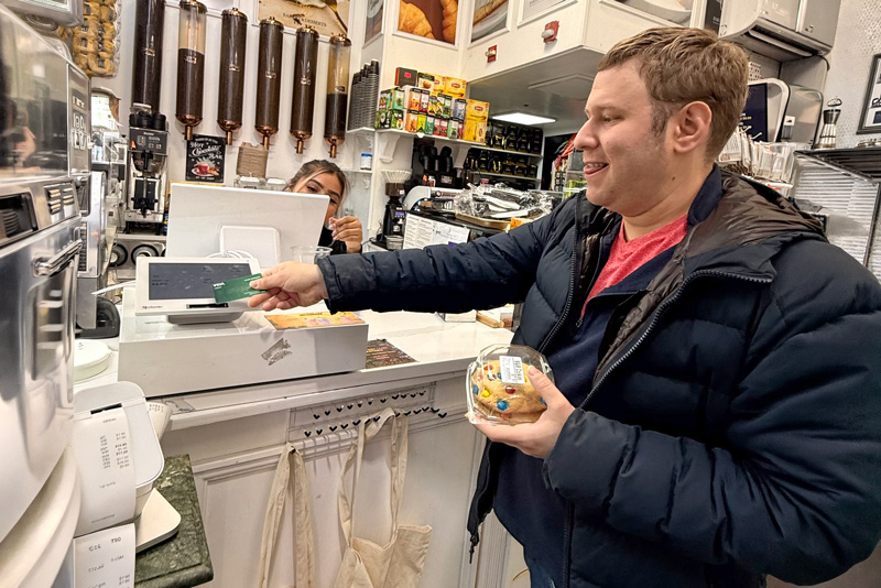 Andrew makes a purchase with his debit card during a recent AABR community outing — an everyday transaction that represents choice, independence and participation.